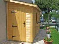 An eine Mauer gelehnte Holzhütte